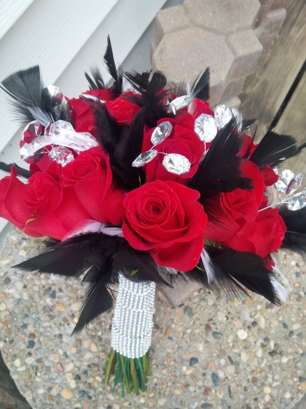Bouquet of red roses with black and white feathers and diamond wrap and bling throughout