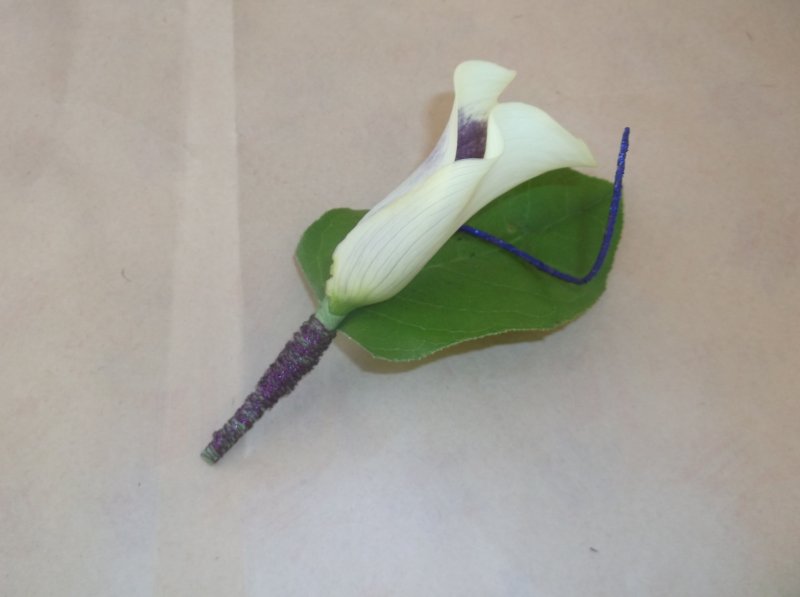 Boutonniere with Mini purple throat calla lily, lemon leaf, purple ting-ting, wire on stem